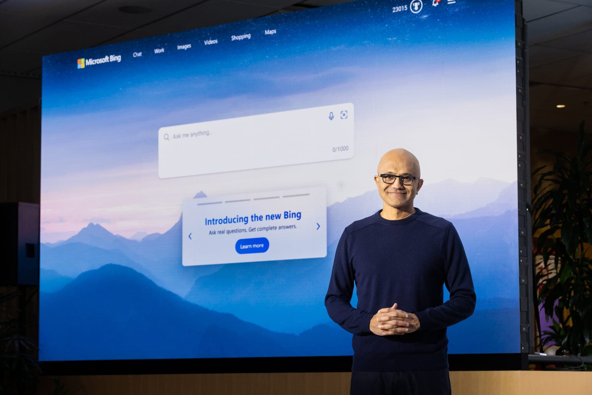 Satya Nadella, CEO de Microsoft, de pie ante una gran pantalla que presenta el nuevo Bing