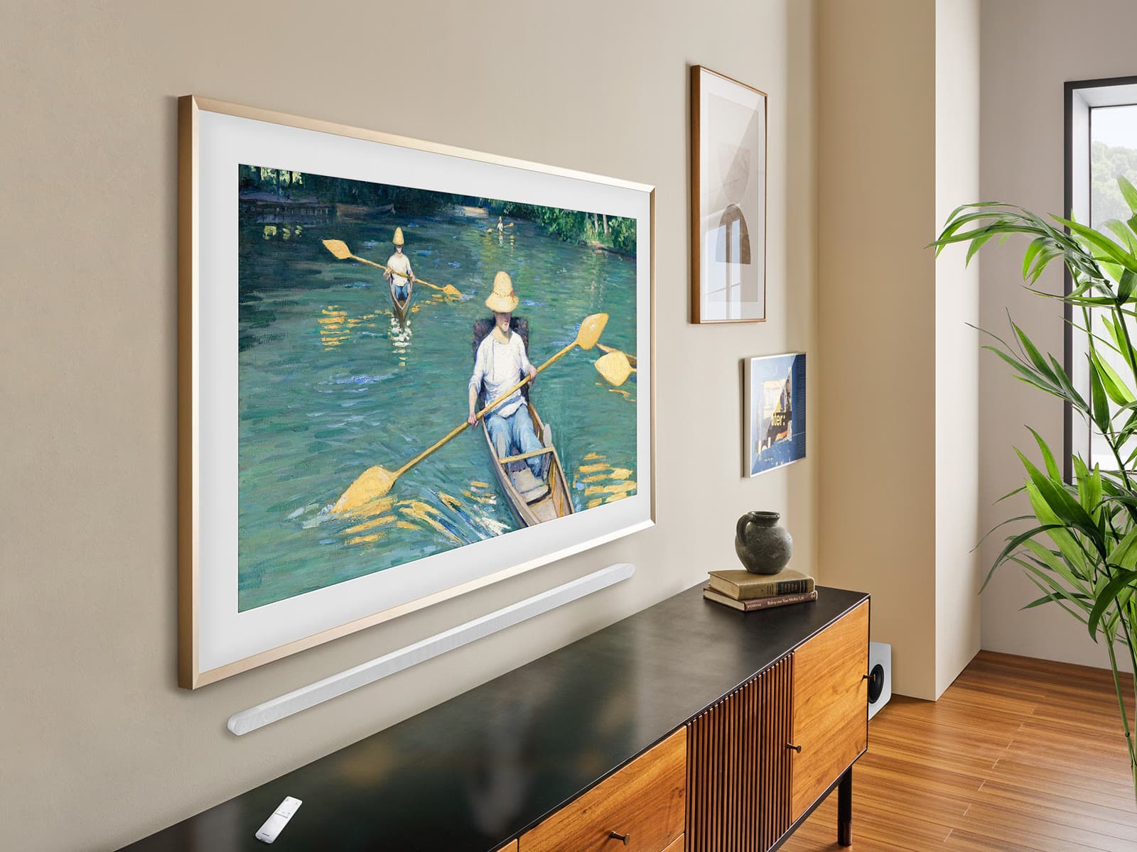 Televisor Samsung The Frame colgado a ras de pared sobre un aparador, con una barra de sonido debajo y sin cables a la vista