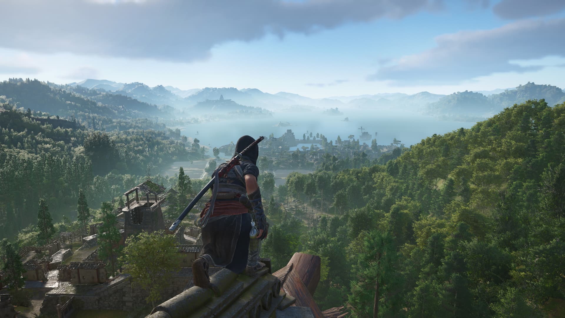Naoe en lo alto de un tejado mirando un valle con un lago y montañas, captura oficial de Assassin's Creed Shadows